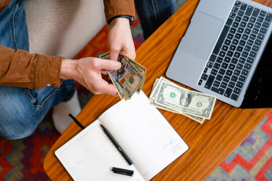 A man counts money indoors