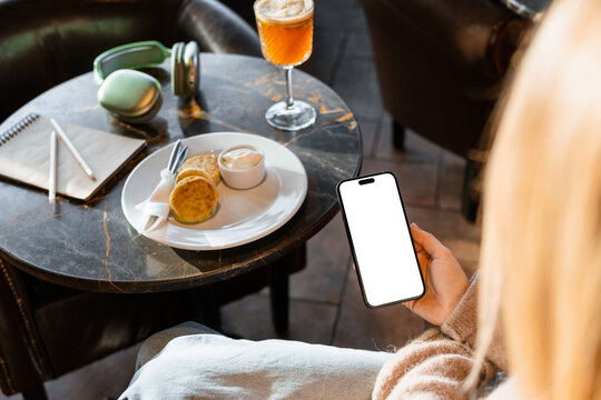 A woman uses a mobile in the cafe