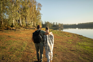 man with down syndrome walking hugging with his friend outdoors