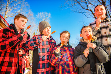 Photo showing children tasting maple syrup with wooden spoon - 777682783