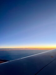 view from the airplane window, sunrise time, tender colors of the sky 