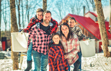 family close to a maple shack having fun together - 777684762
