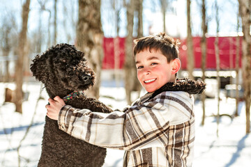 Cute boy playing with happy Goldendoodle on spring season - 777685722