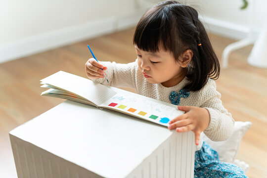 Portrait of little cute child girl holding a paint brush