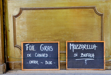 Two blackboards in France at a deli food shop. At the blackboard is written in Franch translated...