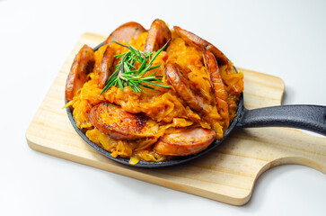 Traditional Polish dish called bigos made of sauerkraut, sausage and mushrooms, food served warm in a cast iron pan - 777690789