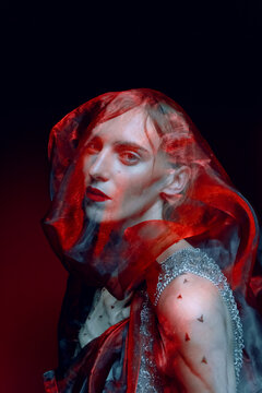 An androgynous model portrait under a veil