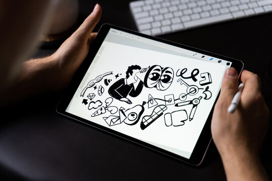 Artist working on digital tablet in a cozy home workspace.
