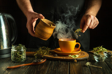 The cook prepares medicinal herbal tea on the kitchen table. Prevention of viral diseases using...
