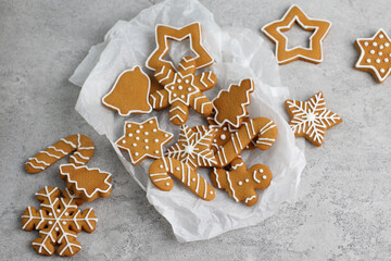 Christmas gingerbread cookies of various shapes on a gray background.