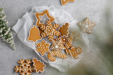 New Year's gingerbread cookies of various shapes with fir trees on a gray background.