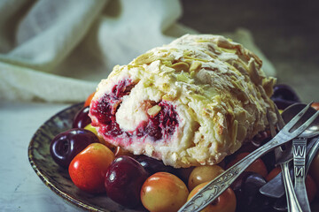 Meringue roll with cherries and almonds, close-up