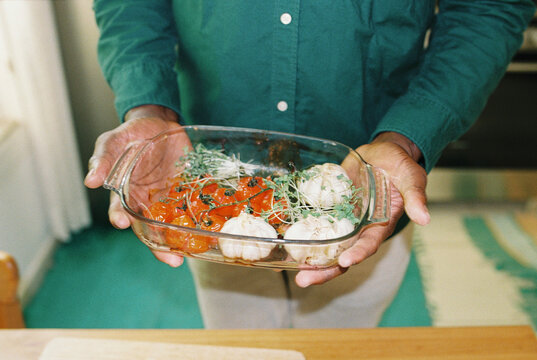 A man with vegetables from an oven