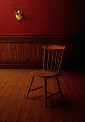 Vintage rustic interior with wooden chair, wooden floor, paneling, deer skull on the wall.