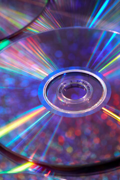 Old compact discs with rainbow light reflection on mirrored surface