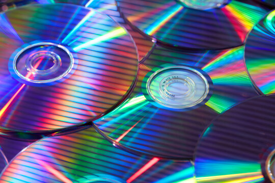 Iridescent light creating stripes on mirrored surface of CD discs