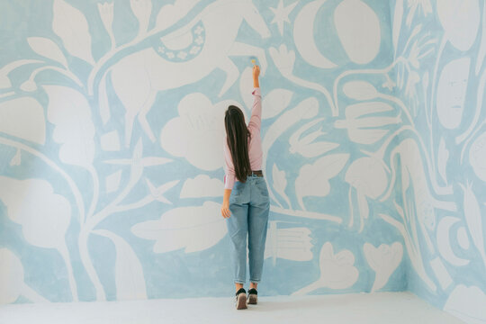 female painter working on mural