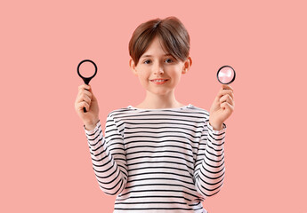 Little boy with magnifiers on pink background