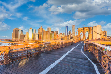 Skyline view of the lower Manhattan from empty Brooklyn Bridge in the foreground during sunrise, NYC