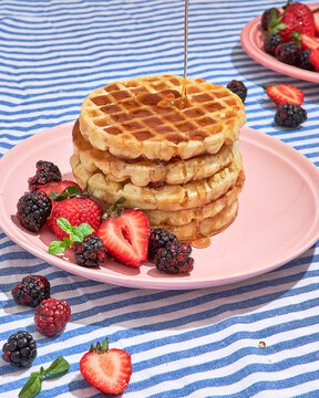 stack of waffles with pouring syrup