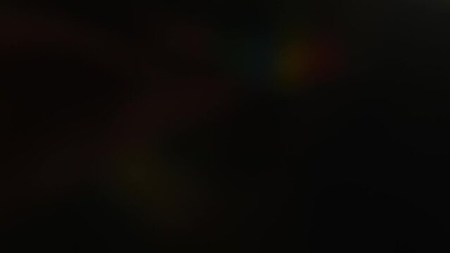 Party horn or blowout unrolls open at black background. Mental psychosis party concept, horror atmosphere celebrations, evil clown in the dark blowing party horn. Halloween entertainment atmosphere.