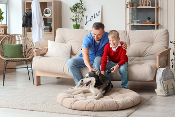 Mature doctor with his little son and Husky dog at home