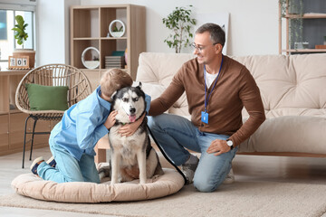 Mature doctor with his little son and cute Husky dog at home