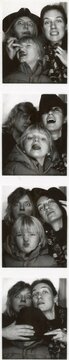 Funny girlfriends with a kid in a photobooth