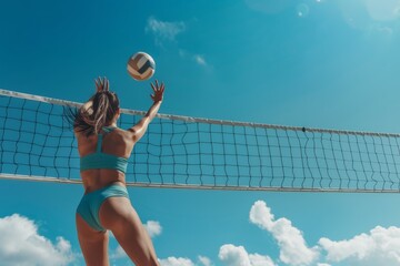 With focus and precision, a female player is about to hit a volleyball over the net on a bright sunny day at the beach