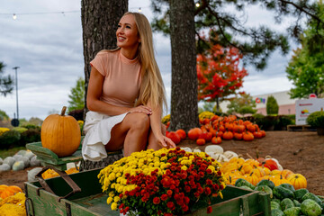 A Lovely Blonde European Model Enjoys Shopping For Pumpkins And Flowers For Halloween Holiday