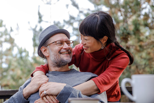 Happy loving couple embracing in balcony at log cabin 