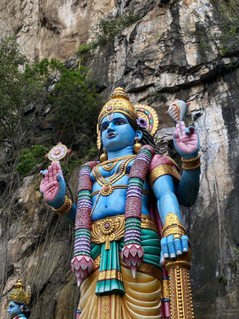 Blue sculpture of Hindu god in rock temple at Batu Caves