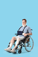 Naklejka premium Injured young man after accident in wheelchair on blue background