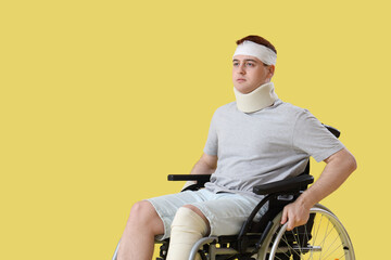 Obraz premium Injured young man after accident in wheelchair on yellow background