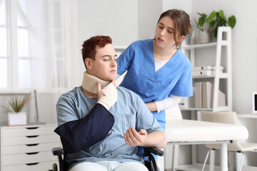 Injured young man after accident in wheelchair with doctor at hospital