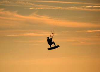 Kitesurfing z latawcem w powietrzu, Kitesurfer na tle pomarańczowego nieba, Kitesurfer w powietrzu, Kitesurfer in action