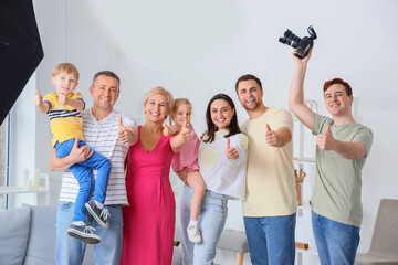 Male photographer with big family showing thumbs-up in studio