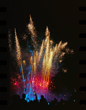 A night show with fireworks and a crowd of spectators with smartphones