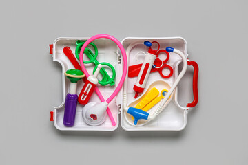 Open toy first aid kit on grey background. Top view