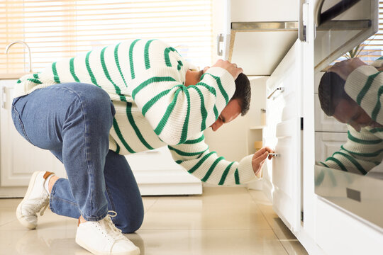 Young man hit his head on drawer in kitchen