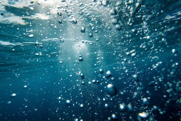 Looking up at the surface of the ocean from below as air bubbles float by