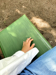 Female hands care. elegant woman's hand on a bench. green color.