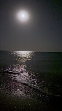 Full blue moon over cold night sea water