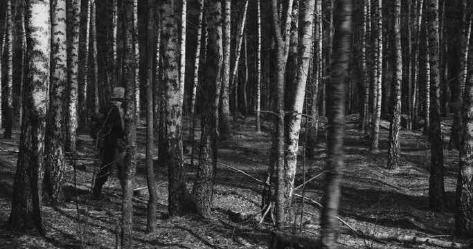 Reenactor Dressed As German Infantry Soldier Combing Forest. Soldier With Carabines Mauser 98k Going By Forest. Reenactment Tactic Game Autumn Season. Wermacht Military Uniform. Black And White Video.