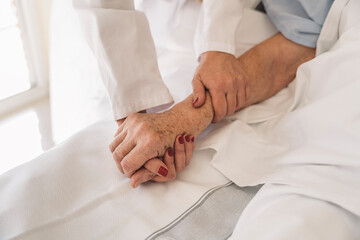 medical doctor holing senior patient's hands