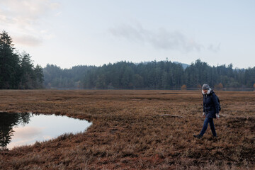 Woman walking outside at the marsh in winter.