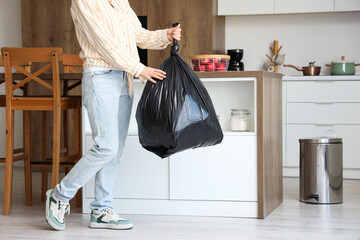 Woman with garbage bag in kitchen