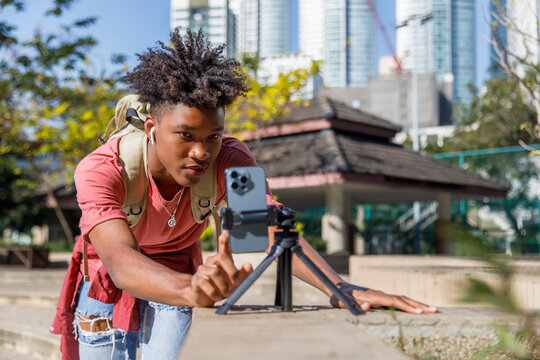 Teenager filming video on smart phone in college campus