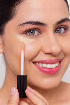 Beauty Portrait of Woman Applying Under-Eye Concealer