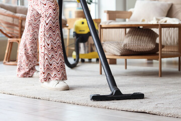 Woman cleaning carpet at home, closeup